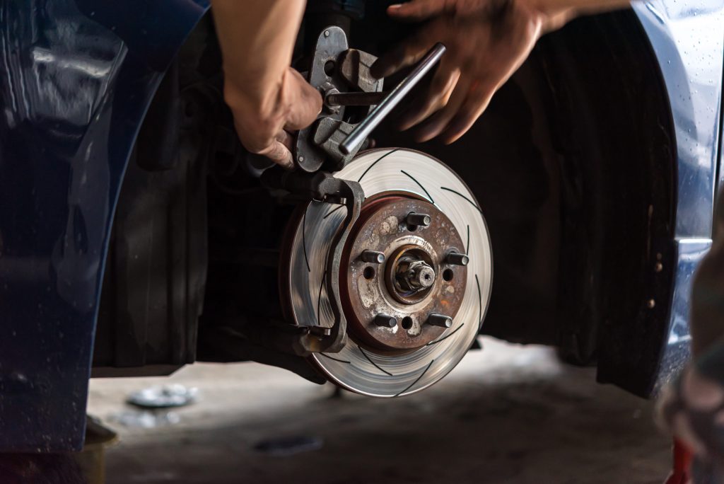 Disc brake and asbestos brake pads at car garage