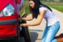Young woman with a flat tire on car