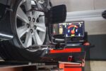 Car on stand with sensors on wheels for wheels alignment camber check in workshop of Service station.